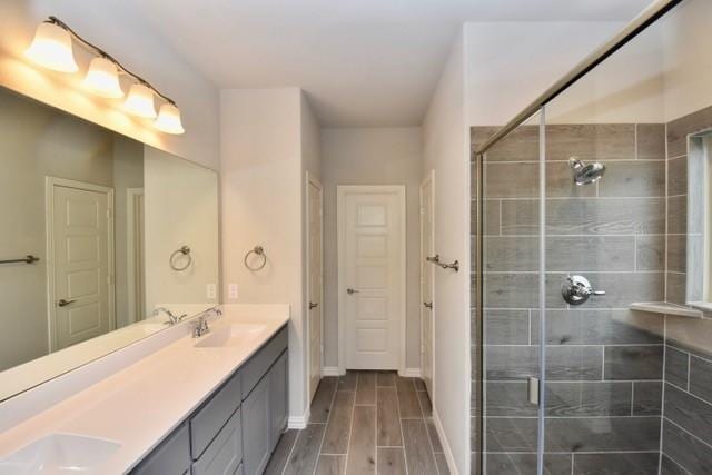 2605 Donella Dr, Denton, TX 76207 - bathroom featuring double vanity, a stall shower, and wood tiled floors