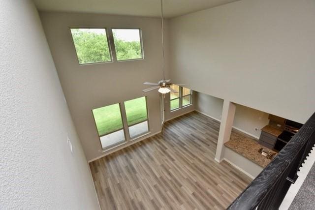 2605 Donella Dr, Denton, TX 76207 - unfurnished living room featuring ceiling fan, plenty of natural light, wood finished floors, and a high ceiling