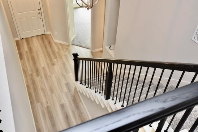 2605 Donella Dr, Denton, TX 76207 - stairway with wood finished floors and a chandelier