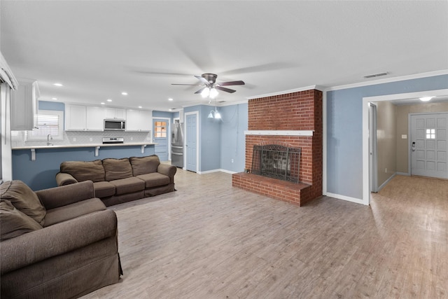 310 Lexington Ave, Abilene, TX 79605 - living area with a fireplace, light wood-type flooring, a ceiling fan, recessed lighting, and ornamental molding