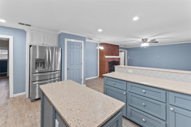 310 Lexington Ave, Abilene, TX 79605 - kitchen with stainless steel fridge with ice dispenser, white cabinets, a ceiling fan, a kitchen island, and light wood-style flooring