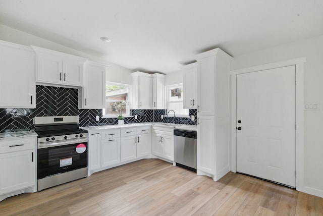 903 N Miller St, Decatur, TX 76234 - kitchen featuring stainless steel appliances, light wood-style floors, tasteful backsplash, and white cabinets
