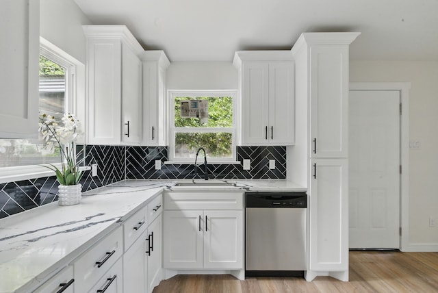 903 N Miller St, Decatur, TX 76234 - kitchen with stainless steel dishwasher, white cabinets, tasteful backsplash, light stone counters, and light wood finished floors