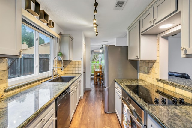 1737 Live Oak Ct, Lewisville, TX 75067 - kitchen featuring black appliances, light wood finished floors, tasteful backsplash, and gray cabinetry