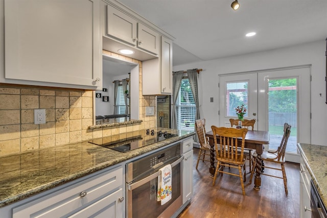 1737 Live Oak Ct, Lewisville, TX 75067 - kitchen with black appliances, dark wood-type flooring, tasteful backsplash, white cabinetry, and recessed lighting