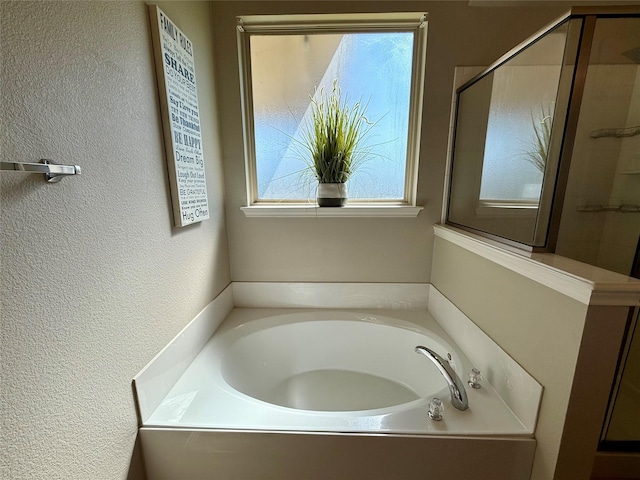 1117 Prairie Heights Dr, Fort Worth, TX 76108 - bathroom featuring a bath, a stall shower, and a textured wall