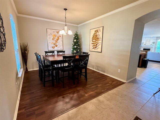 1117 Prairie Heights Dr, Fort Worth, TX 76108 - dining room with arched walkways, crown molding, a chandelier, and wood finished floors