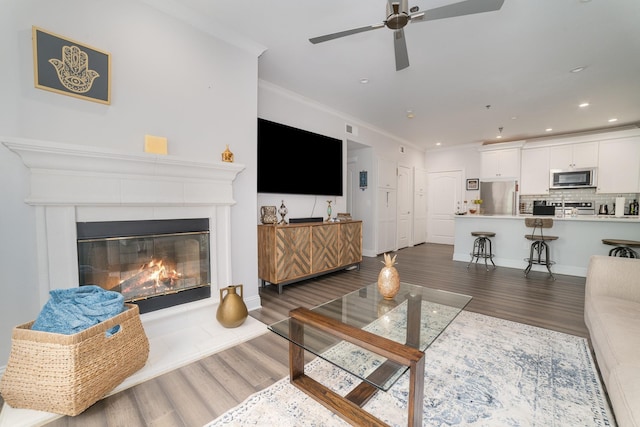 3400 Welborn St Unit 224, Dallas, TX 75219 - living room with wood finished floors, ornamental molding, a ceiling fan, a glass covered fireplace, and recessed lighting