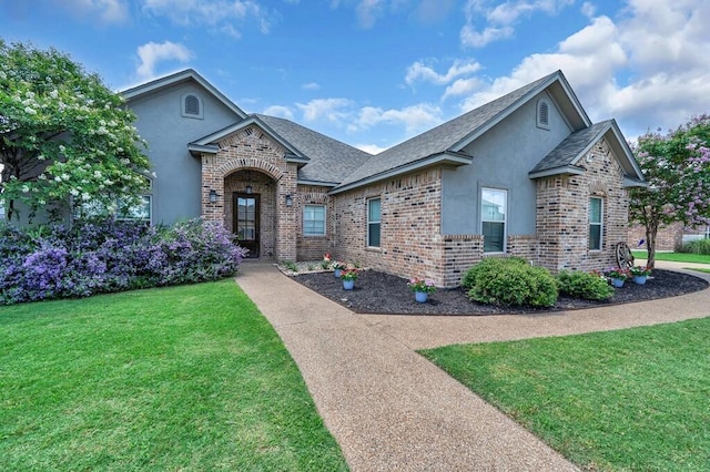 5432 Zavalla Dr, Waco, TX 76708 - view of front of house featuring stucco siding, brick siding, a front yard, and roof with shingles