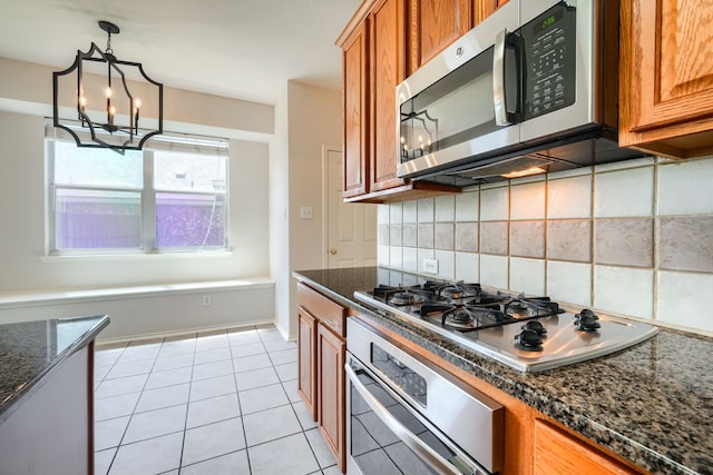 4424 Ridge Point Ln, Plano, TX 75024 - kitchen featuring appliances with stainless steel finishes, brown cabinets, decorative backsplash, a chandelier, and dark stone counters