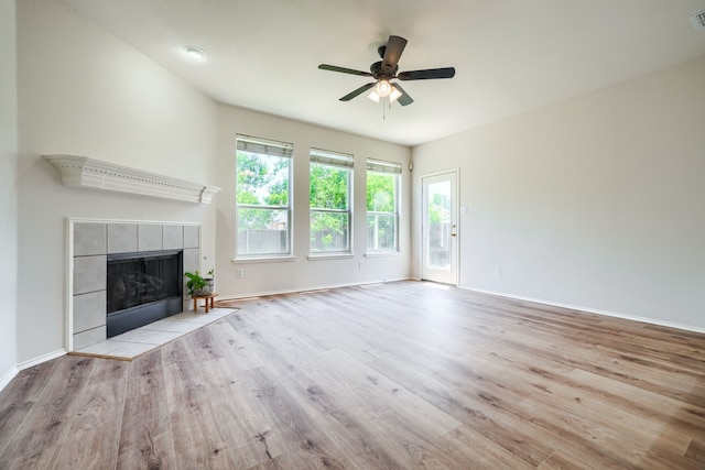 4424 Ridge Point Ln, Plano, TX 75024 - unfurnished living room with wood finished floors, ceiling fan, and a tiled fireplace