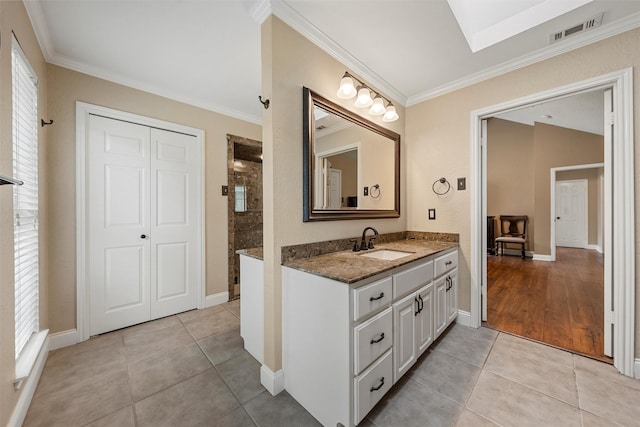 9600 Old Farm Rd, Woodway, TX 76712 - bathroom with vanity, ornamental molding, tile patterned floors, a tile shower, and a skylight