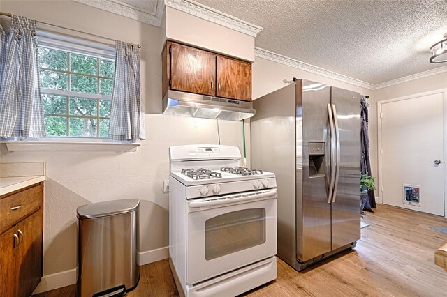 531 Himes Dr, Euless, TX 76039 - kitchen featuring white range with gas cooktop, under cabinet range hood, stainless steel refrigerator with ice dispenser, brown cabinetry, and a textured ceiling