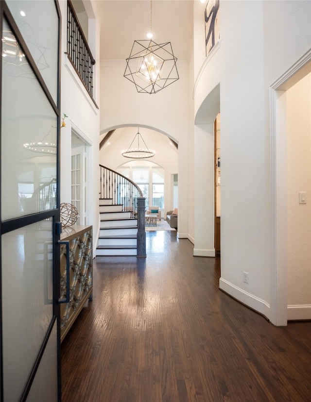 13896 Evergreen Dr, Frisco, TX 75035 - entryway featuring a chandelier, wood finished floors, arched walkways, stairs, and a towering ceiling
