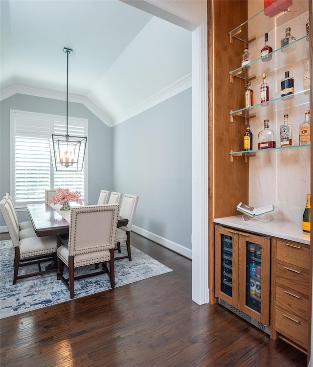 13896 Evergreen Dr, Frisco, TX 75035 - dining room featuring ornamental molding, vaulted ceiling, dark wood-style flooring, a dry bar, and wine cooler