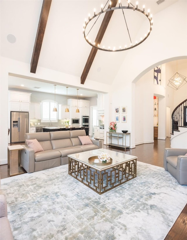 13896 Evergreen Dr, Frisco, TX 75035 - living room with a chandelier, dark wood-type flooring, high vaulted ceiling, stairway, and arched walkways