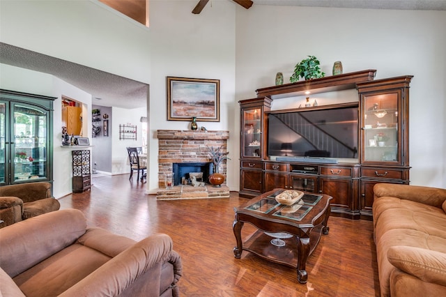 1405 Mapleton Ct, Arlington, TX 76018 - living room with ceiling fan, dark wood-type flooring, vaulted ceiling, and a stone fireplace