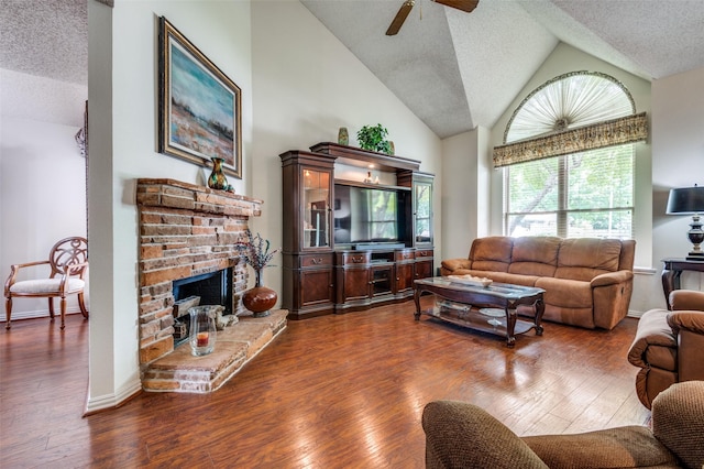 1405 Mapleton Ct, Arlington, TX 76018 - living area with a textured ceiling, ceiling fan, dark wood-style flooring, a fireplace, and high vaulted ceiling