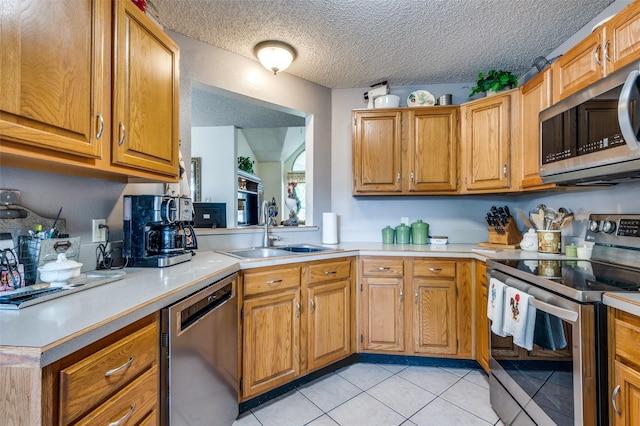1405 Mapleton Ct, Arlington, TX 76018 - kitchen featuring stainless steel appliances, light countertops, light tile patterned flooring, brown cabinetry, and a textured ceiling