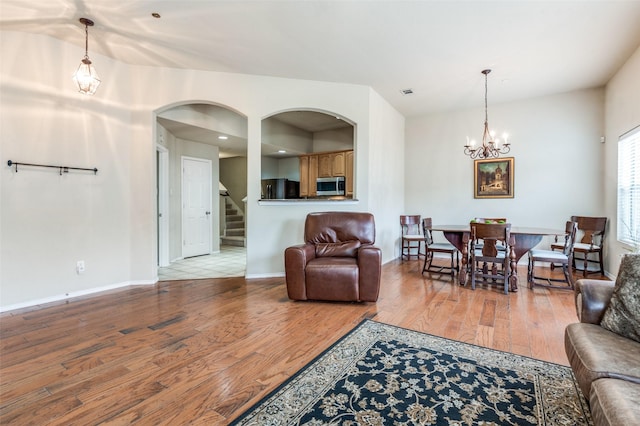 1138 Sophia St, Allen, TX 75013 - living room featuring a chandelier, wood finished floors, stairway, and arched walkways