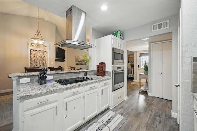 864 Warwick Dr, Plano, TX 75023 - kitchen featuring stainless steel appliances, island exhaust hood, a peninsula, white cabinets, and wood finished floors