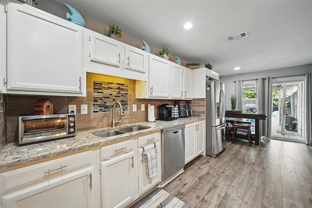 864 Warwick Dr, Plano, TX 75023 - kitchen with appliances with stainless steel finishes, white cabinetry, light wood-type flooring, and recessed lighting