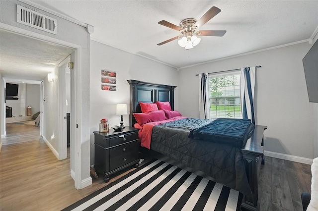 864 Warwick Dr, Plano, TX 75023 - bedroom featuring wood finished floors, a textured ceiling, crown molding, and ceiling fan