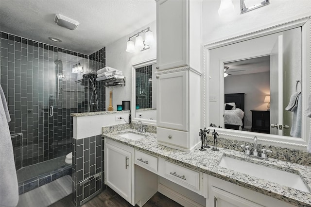 864 Warwick Dr, Plano, TX 75023 - full bathroom with ensuite bathroom, double vanity, a stall shower, a ceiling fan, and a textured ceiling
