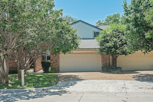 1441 Earlshire Pl, Plano, TX 75075 - view of property hidden behind natural elements featuring driveway, an attached garage, and brick siding