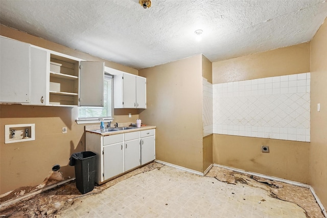 3824 Stuart Dr, Fort Worth, TX 76110 - washroom with electric dryer hookup, cabinet space, hookup for a washing machine, a textured ceiling, and light flooring