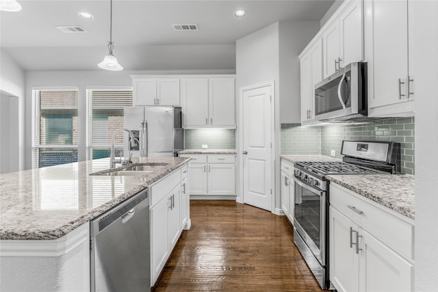 5608 Grove Cove Dr, Mckinney, TX 75071 - kitchen featuring appliances with stainless steel finishes, dark wood finished floors, white cabinetry, decorative backsplash, and decorative light fixtures