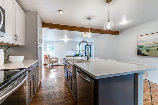 10649 Sylvia Dr, Dallas, TX 75228 - kitchen featuring appliances with stainless steel finishes, wood finished floors, tasteful backsplash, light countertops, and beam ceiling