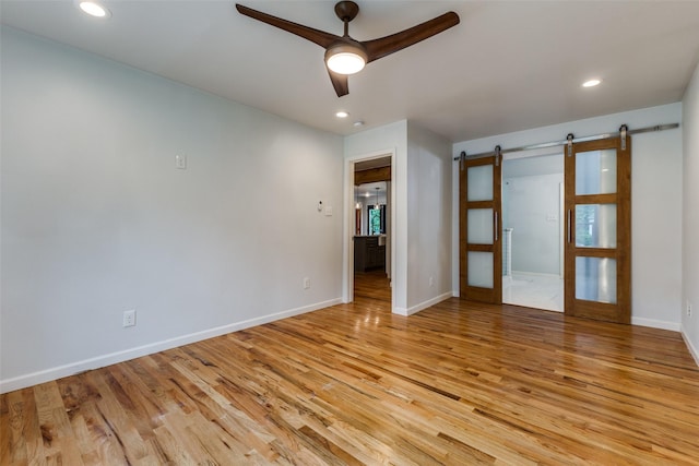 10649 Sylvia Dr, Dallas, TX 75228 - spare room with a barn door, a ceiling fan, light wood-style flooring, and recessed lighting