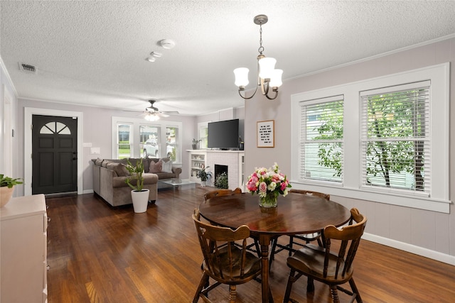 1617 Virginia Pl, Fort Worth, TX 76107 - dining space with a textured ceiling, dark wood-style flooring, crown molding, a fireplace, and a ceiling fan