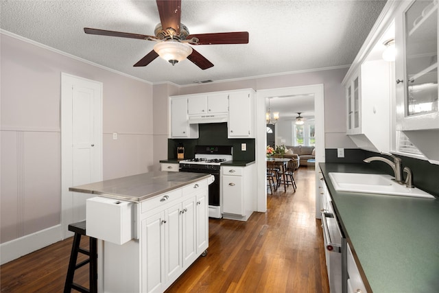 1617 Virginia Pl, Fort Worth, TX 76107 - kitchen featuring gas stove, a ceiling fan, dark wood-style floors, white cabinetry, and a textured ceiling