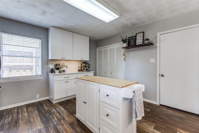 2521 Ridgecrest Dr, Garland, TX 75041 - kitchen featuring dark wood-type flooring, white cabinets, a kitchen island, and butcher block countertops