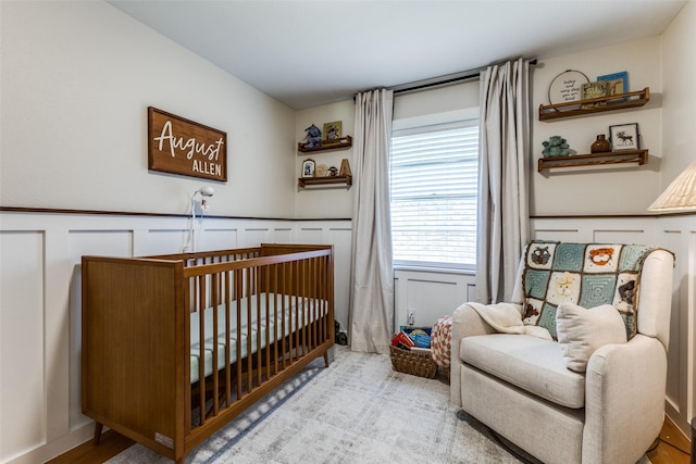2521 Ridgecrest Dr, Garland, TX 75041 - bedroom featuring a nursery area and a wainscoted wall
