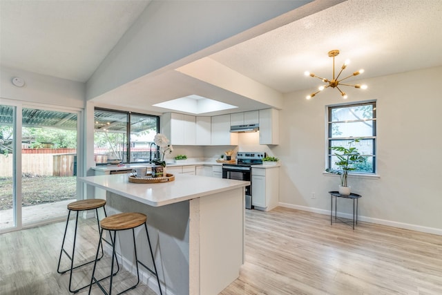409 Brookview Dr, Garland, TX 75043 - kitchen featuring stainless steel electric range oven, light wood-style floors, light countertops, and white cabinetry