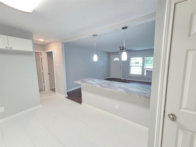 2110 W Bond St, Denison, TX 75020 - kitchen with ceiling fan, white cabinetry, decorative light fixtures, cooling unit, and light countertops