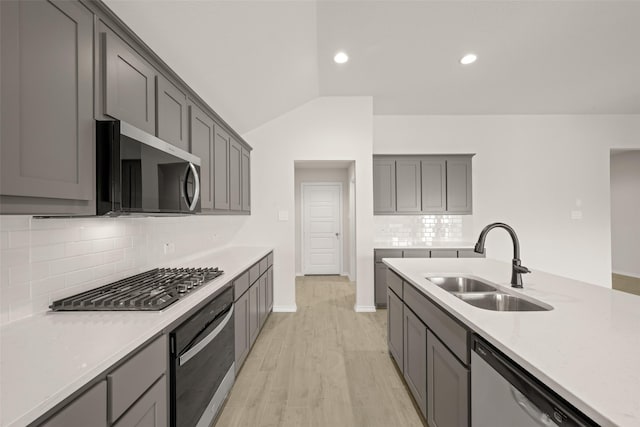 733 Stone Eagle Dr, Azle, TX 76020 - kitchen featuring stainless steel appliances, decorative backsplash, gray cabinetry, light countertops, and lofted ceiling