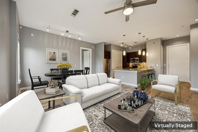2950 Mckinney Ave Unit 419, Dallas, TX 75204 - kitchen featuring freestanding refrigerator, a ceiling fan, light wood-style floors, dark brown cabinets, and hanging light fixtures