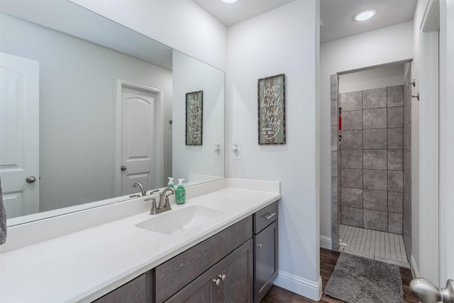 111 Arrowhead Dr, Sanger, TX 76266 - bathroom featuring vanity, a tile shower, and wood finished floors