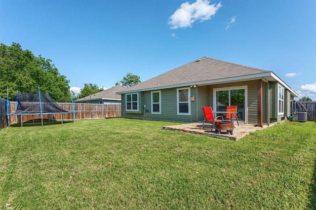 111 Arrowhead Dr, Sanger, TX 76266 - rear view of house with a trampoline, a fenced backyard, a patio area, and a shingled roof