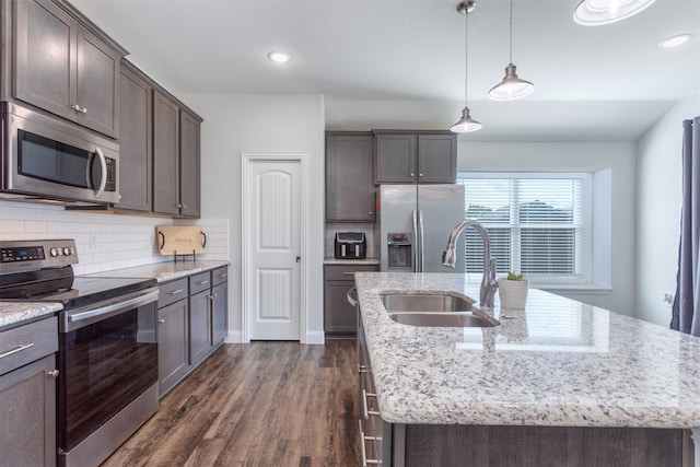 111 Arrowhead Dr, Sanger, TX 76266 - kitchen featuring stainless steel appliances, a center island with sink, dark brown cabinetry, decorative backsplash, and dark wood-style floors
