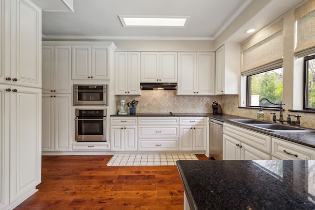 3217 Oak Tree Ln, Grapevine, TX 76051 - kitchen with stainless steel dishwasher, under cabinet range hood, dark wood-style floors, backsplash, and ornamental molding