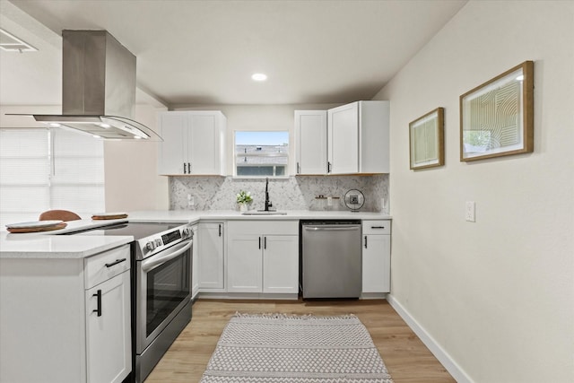 709 E Gandy St, Denison, TX 75021 - kitchen featuring stainless steel appliances, island range hood, tasteful backsplash, white cabinetry, and light countertops