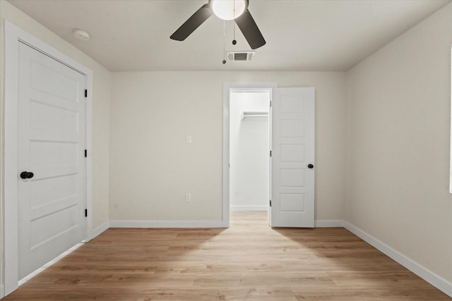 709 E Gandy St, Denison, TX 75021 - unfurnished bedroom with light wood-style flooring, a walk in closet, a ceiling fan, and a closet