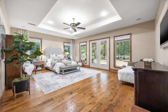 2702 Hidden Trails Rd, Royse City, TX 75189 - bedroom featuring a tray ceiling, access to exterior, multiple windows, wood finished floors, and recessed lighting