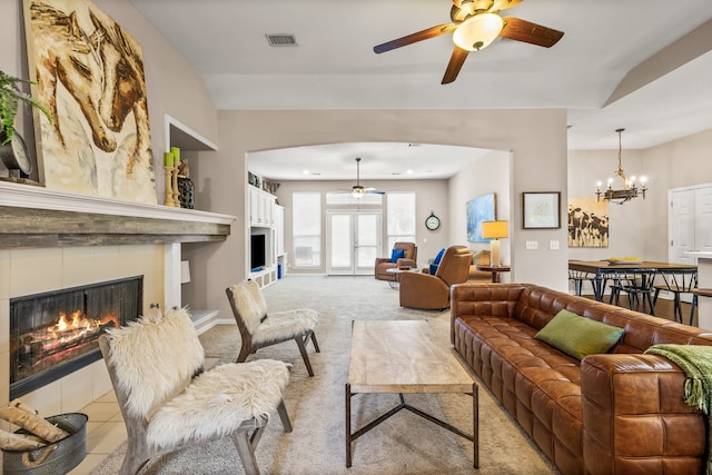 8601 Prescott Cir, Frisco, TX 75034 - living area with a tiled fireplace, a ceiling fan, light carpet, and a chandelier