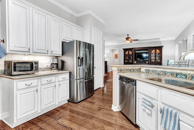 4404 Barnsley Dr, Plano, TX 75093 - kitchen with stainless steel appliances, wood finished floors, a ceiling fan, backsplash, and white cabinets